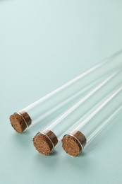 Photo of Test tubes on turquoise background, closeup. Laboratory glassware