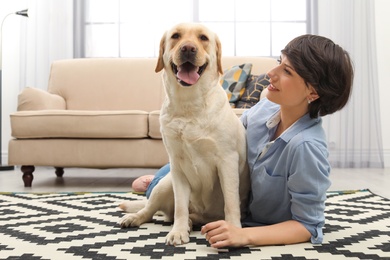 Photo of Adorable yellow labrador retriever with owner at home