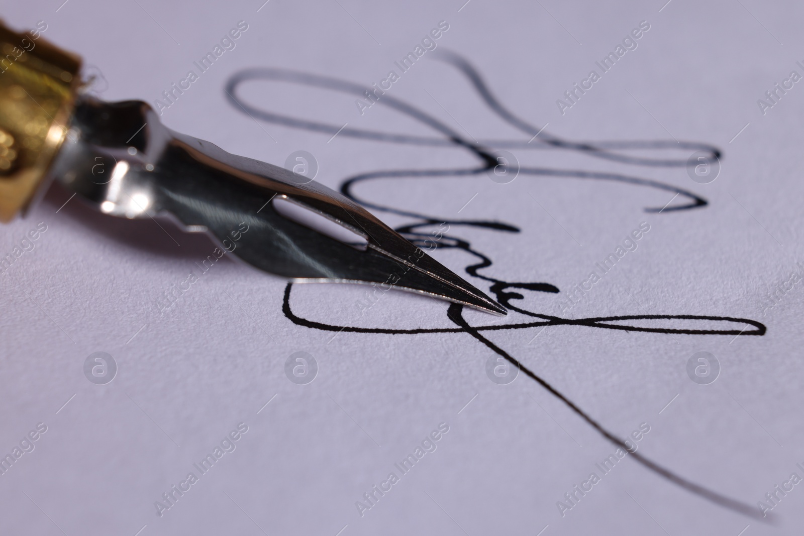 Photo of Fountain pen and signature on sheet of paper, closeup