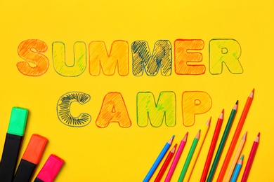 Photo of Markers, pencils and words SUMMER CAMP on color background, top view