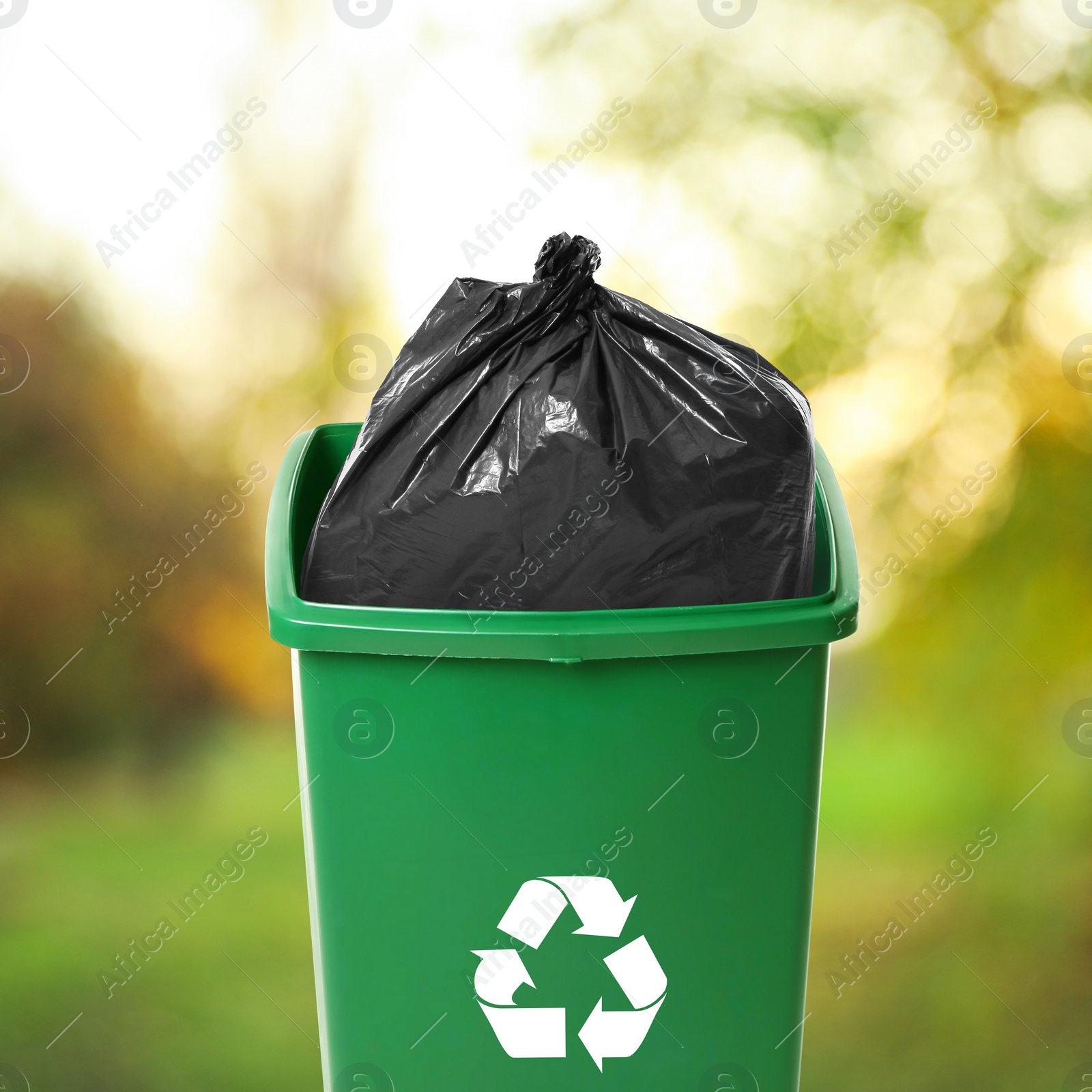 Image of Waste bin with plastic bag full of garbage on blurred background