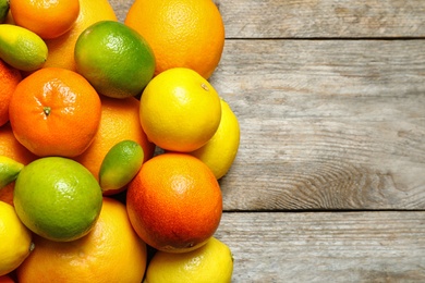 Flat lay composition with different citrus fruits and space for text on wooden background