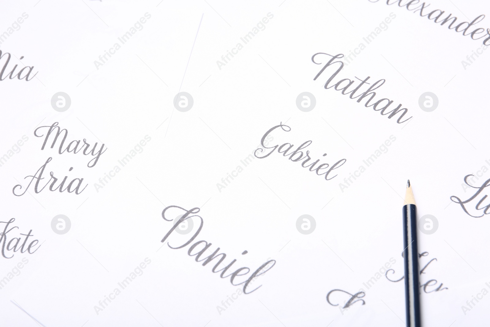 Photo of Ordinary pencil and different baby names written on paper, closeup