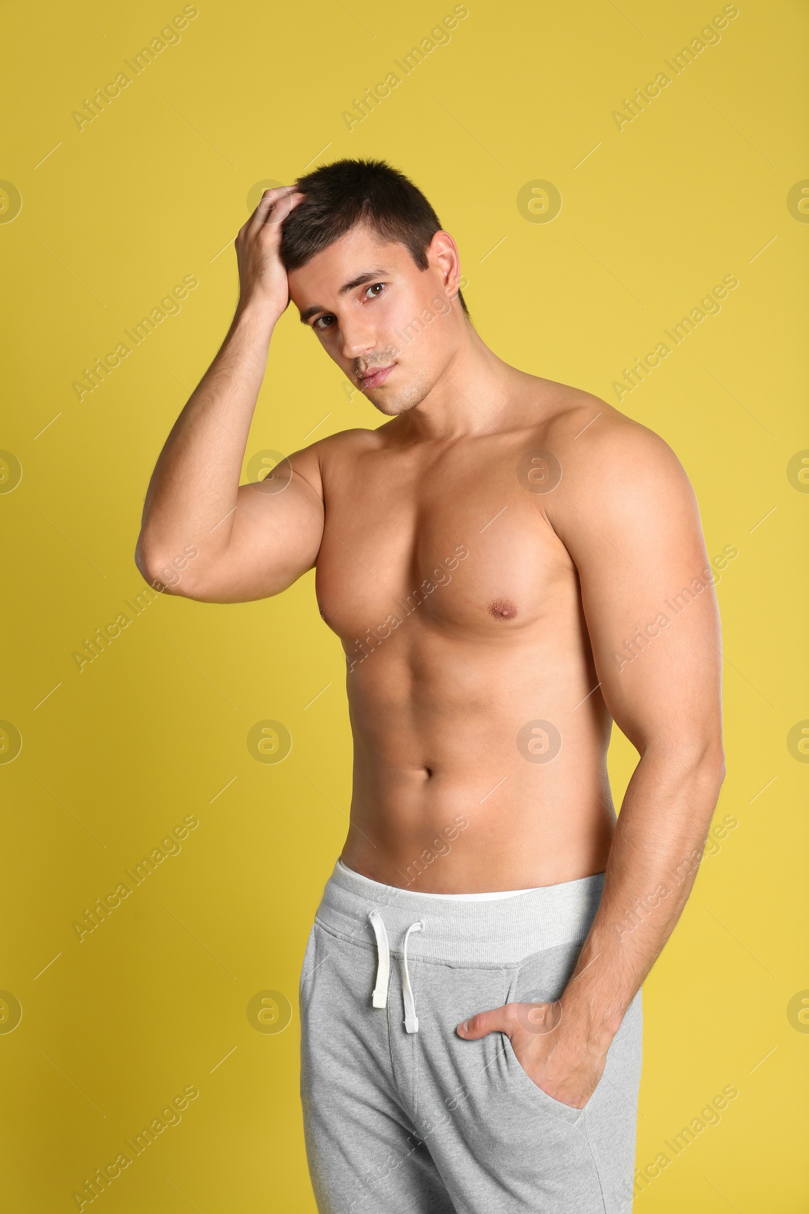 Photo of Man with sexy body on yellow background