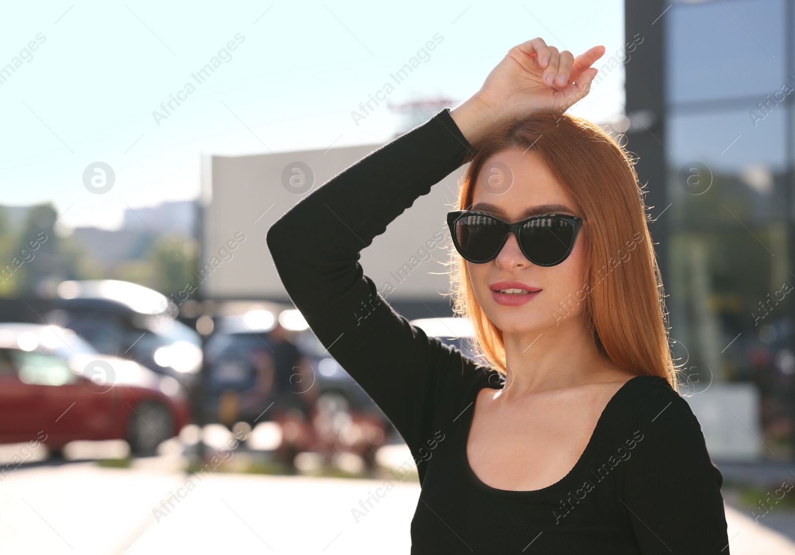 Photo of Beautiful woman in sunglasses on city street, space for text