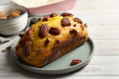 Photo of Delicious pumpkin bread with pecan nuts on light wooden table, closeup. Space for text