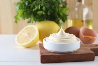 Photo of Fresh mayonnaise sauce in bowl on white wooden table, space for text