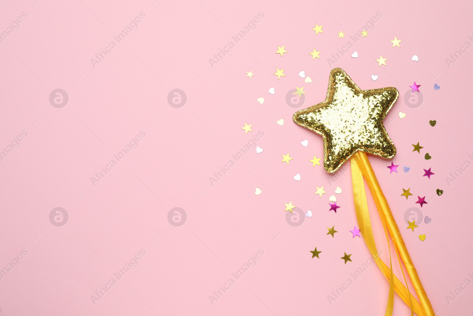 Photo of Beautiful golden magic wand and confetti on pink background, flat lay. Space for text