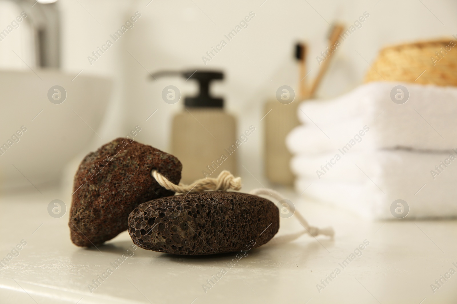 Photo of Pumice stones on white countertop in bathroom, closeup. Space for text