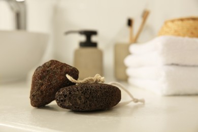 Pumice stones on white countertop in bathroom, closeup. Space for text