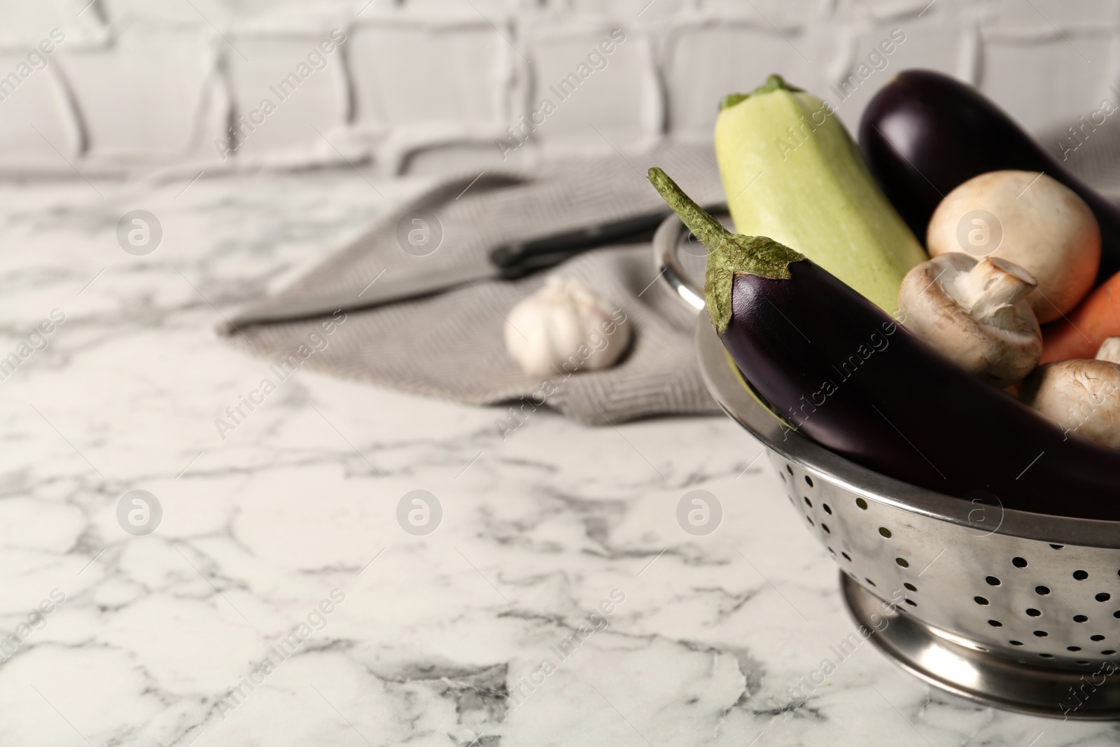 Photo of Fresh vegetables on white marble table, closeup. Space for text