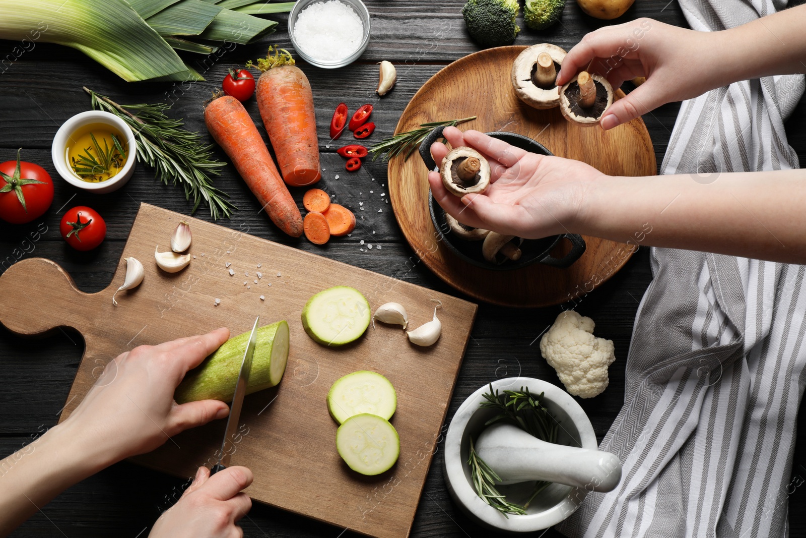 Photo of Women cooking at black wooden table, top view