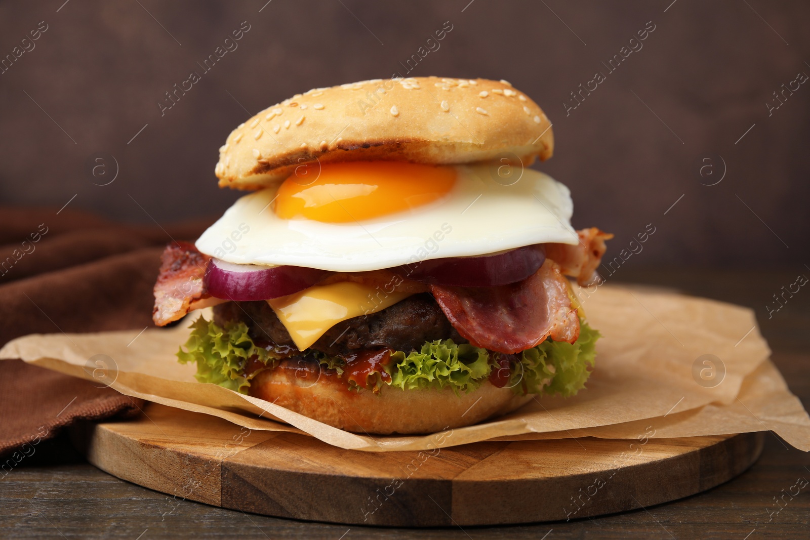 Photo of Delicious burger with fried egg on wooden table