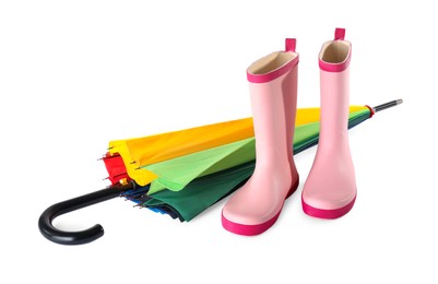 Photo of Pink rubber boots and colorful umbrella on white background