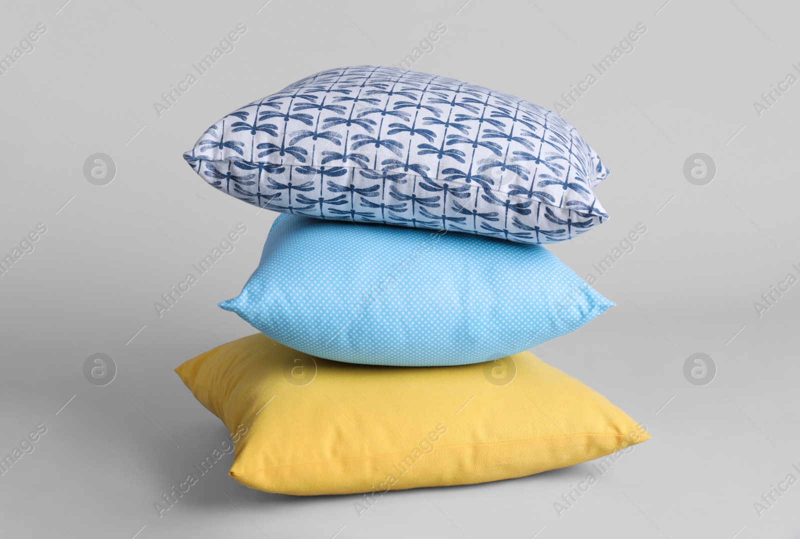 Photo of Stack of stylish soft pillows on grey background