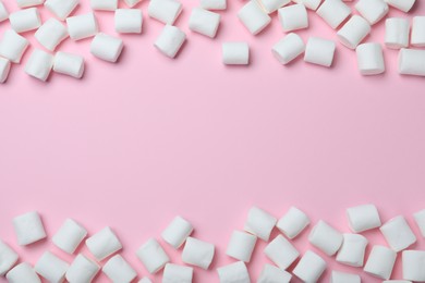 Delicious puffy marshmallows on pink background, flat lay. Space for text