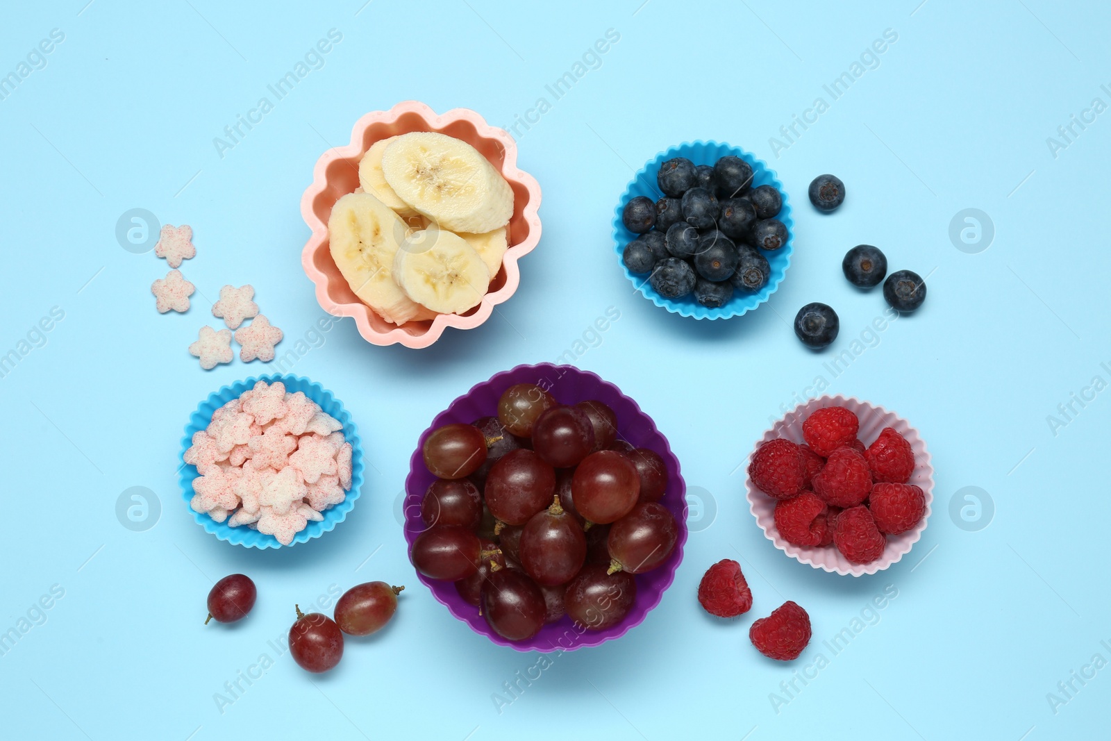 Photo of Different finger foods for baby on light blue background, flat lay