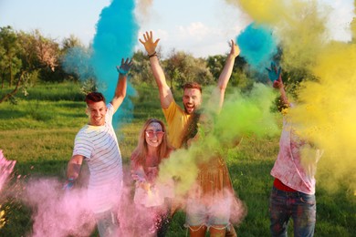 Photo of Happy friends having fun with colorful powder dyes outdoors. Holi festival celebration