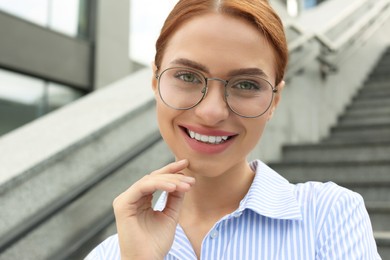 Photo of Portrait of beautiful woman in glasses outdoors, closeup