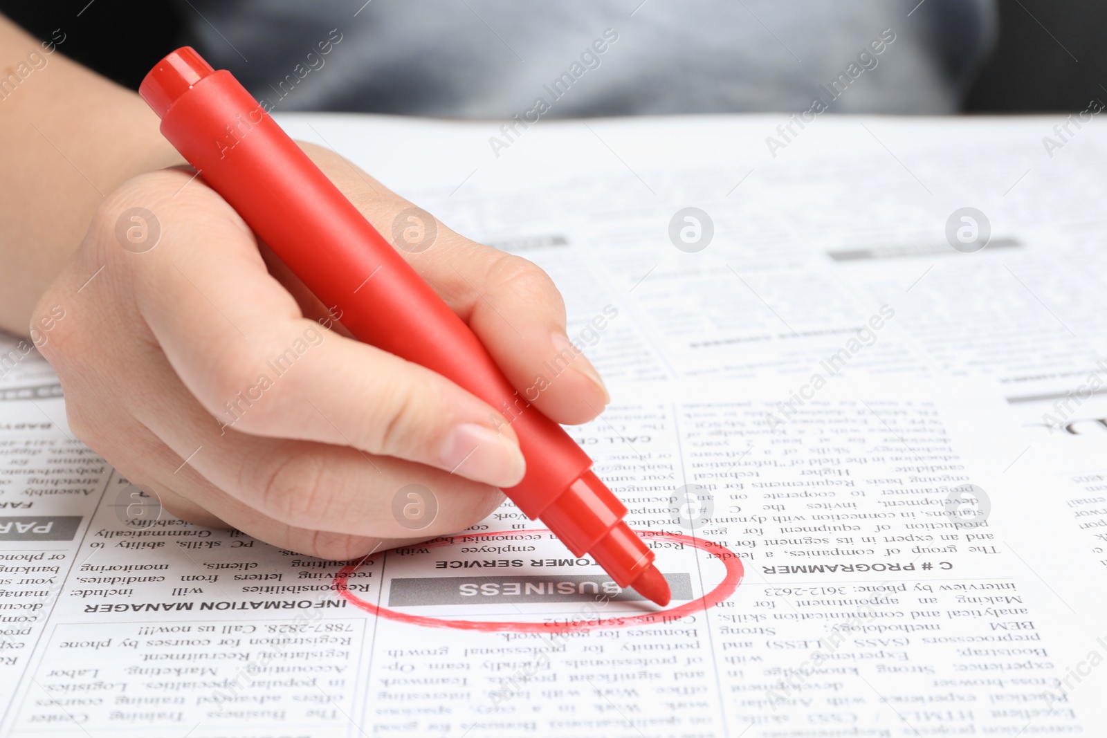 Photo of Woman marking advertisement in newspaper, closeup. Job search concept