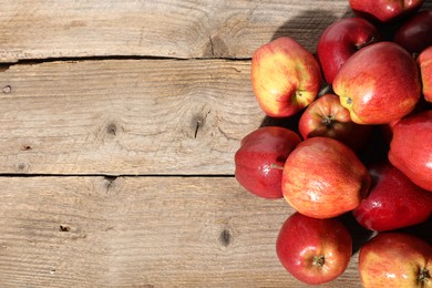 Photo of Many fresh apples with water drops on wooden table, top view. Space for text