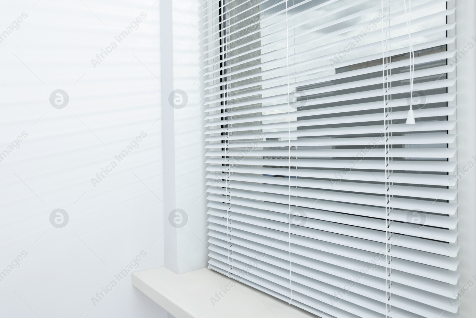 Photo of Stylish window with horizontal blinds in room