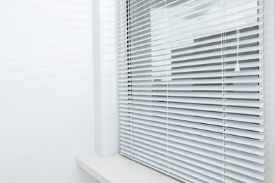 Stylish window with horizontal blinds in room
