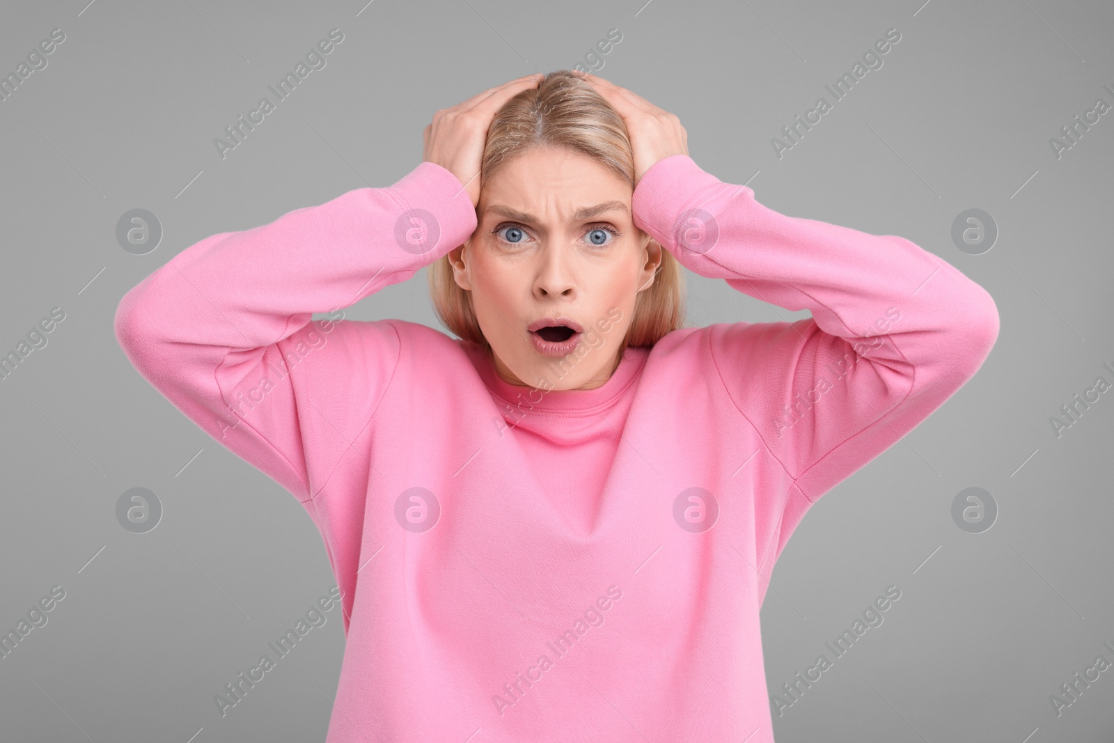 Photo of Portrait of surprised woman on grey background