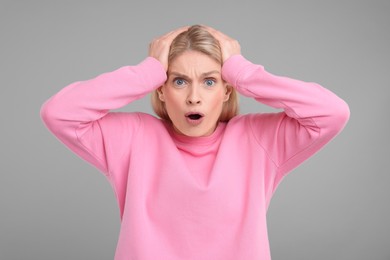 Photo of Portrait of surprised woman on grey background