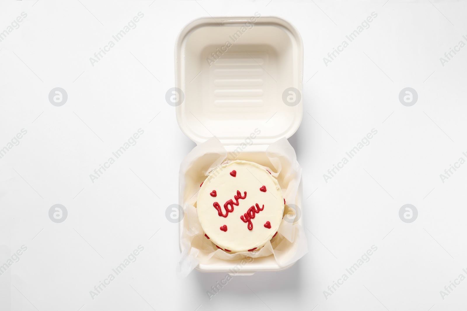 Photo of Bento cake with Love You text in takeaway box on white table, top view. St. Valentine's day surprise