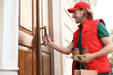 Male courier with order at entrance. Food delivery service