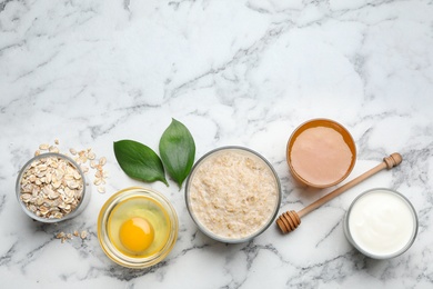 Photo of Handmade face mask and ingredients on white marble table, flat lay. Space for text