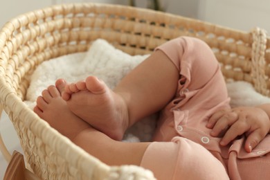 Photo of Cute little baby sleeping in wicker crib at home, closeup