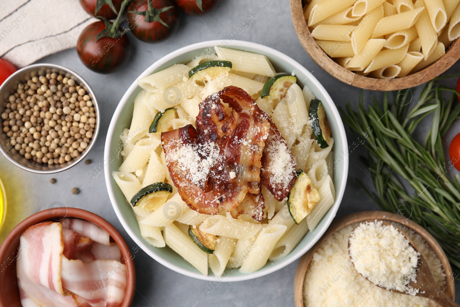 Photo of Tasty pasta with bacon and cheese on grey table, top view