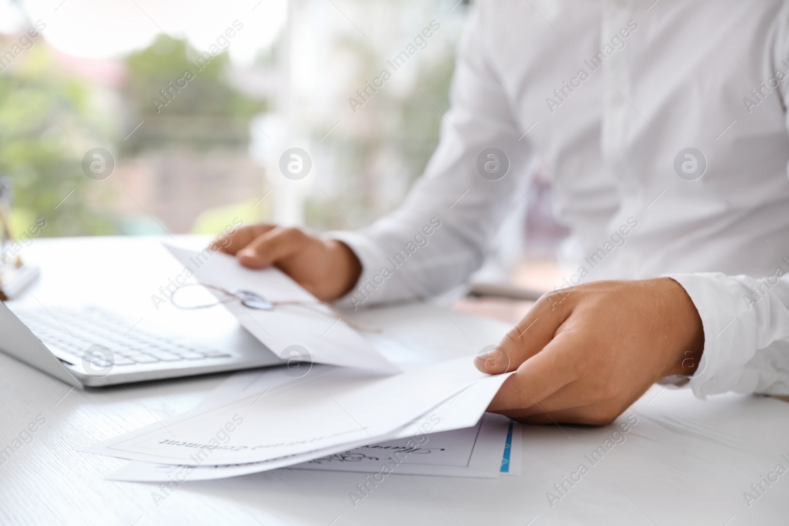 Photo of Male notary with documents and laptop at table in office, closeup