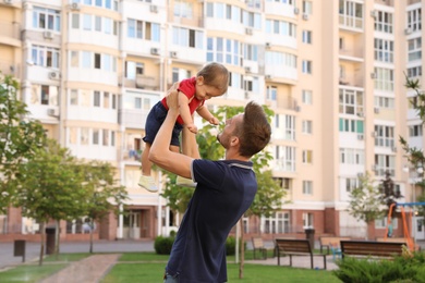 Photo of Father with adorable little baby outdoors. Happy family