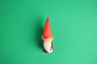 Photo of Dwarf made from plasticine on green background, top view. Children's handmade ideas