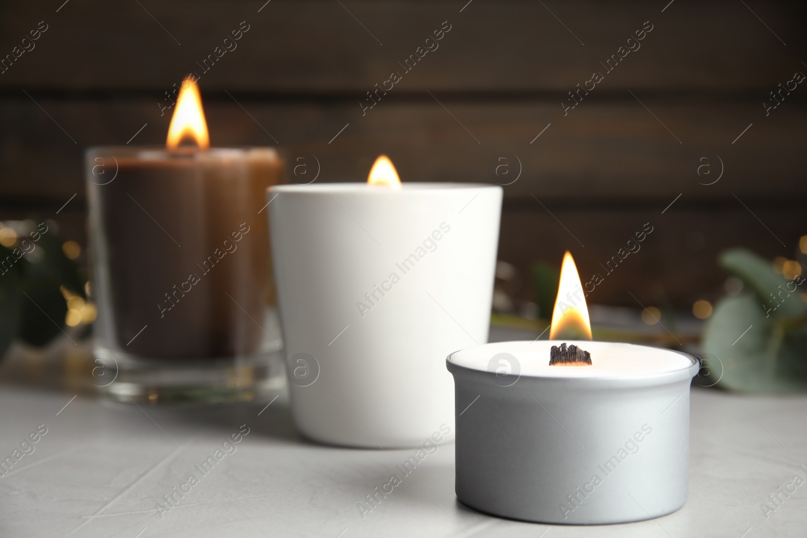 Photo of Burning scented candles on light grey table