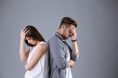 Photo of Upset young couple on grey background. Relationship problems