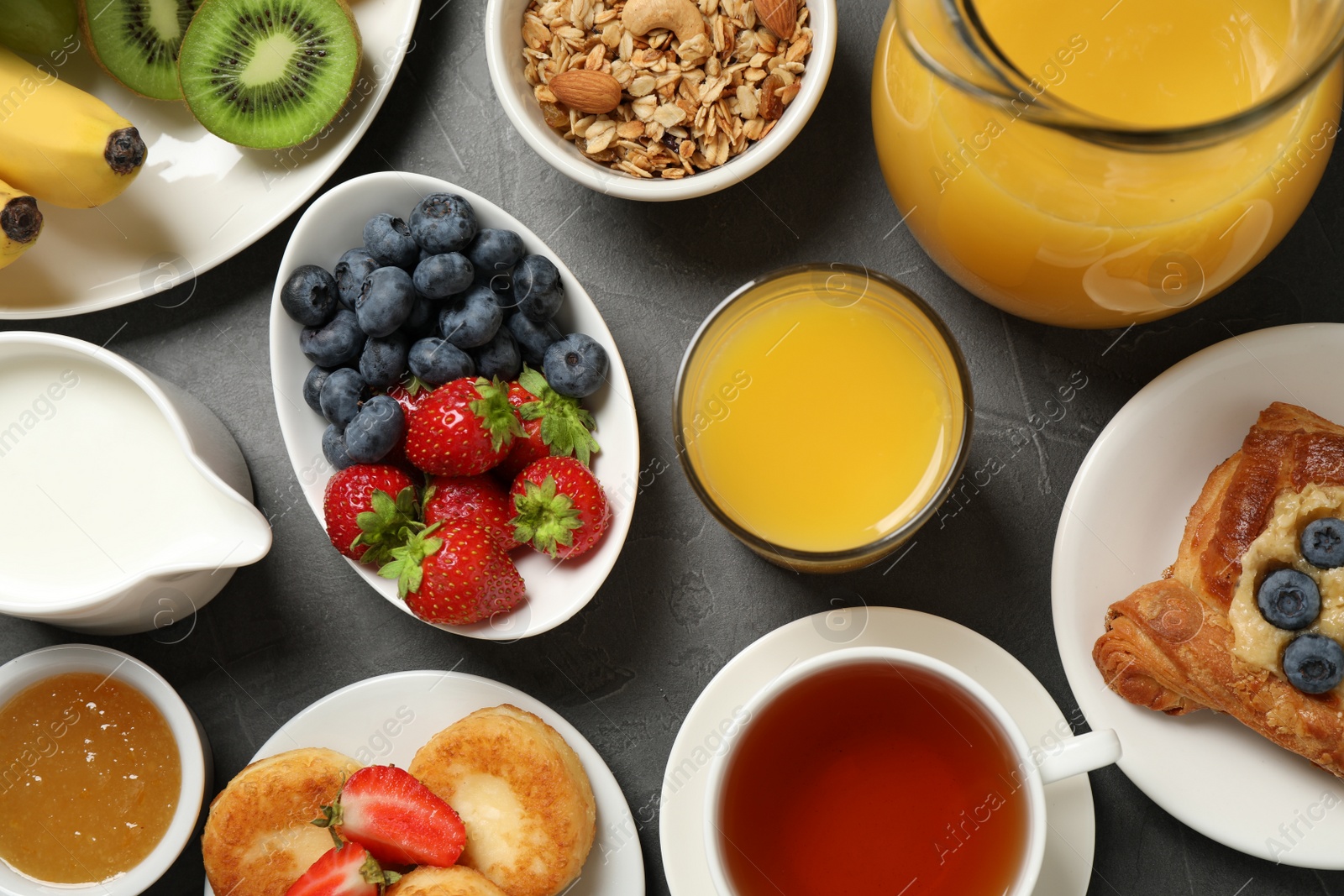 Photo of Buffet service. Tasty breakfast served on grey table, flat lay