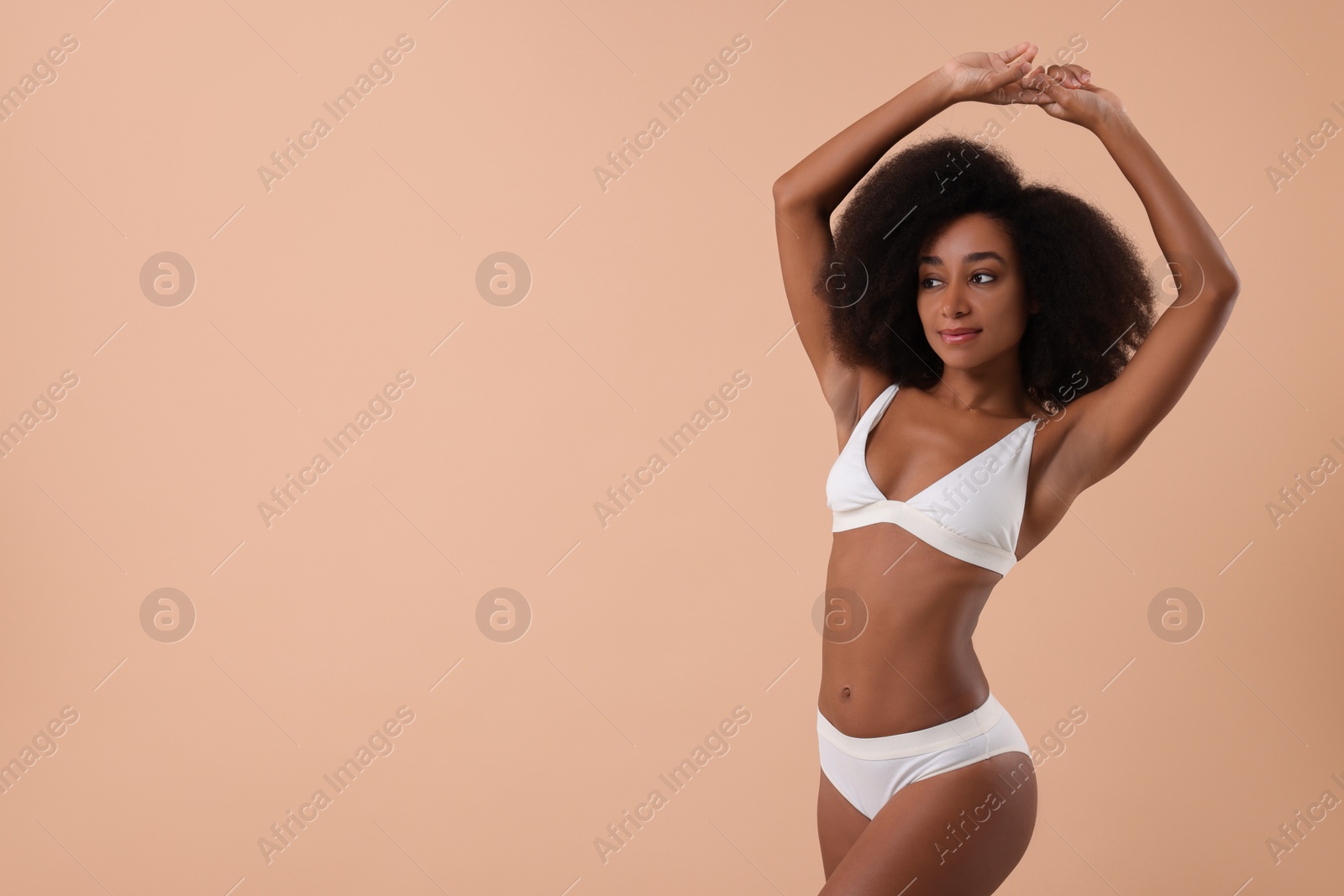 Photo of Beautiful woman in stylish bikini on beige background, space for text