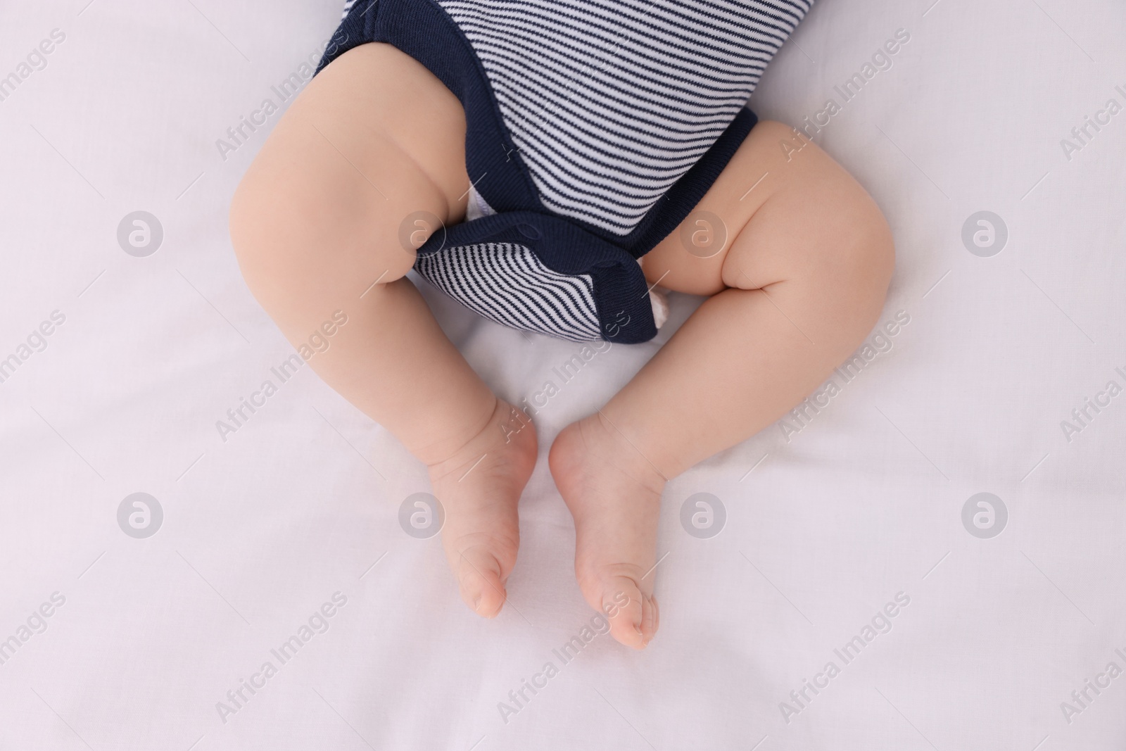 Photo of Newborn baby lying on white blanket, top view