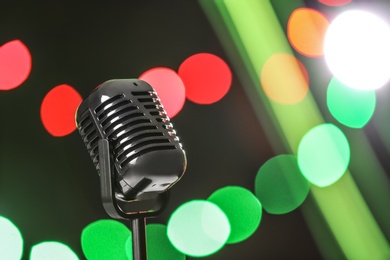 Photo of Retro microphone against festive lights, space for text. Musical equipment