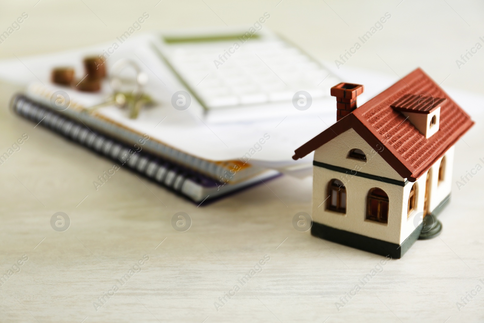 Photo of House model and real estate agent's items on light table