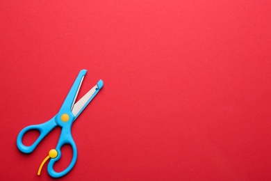 Training scissors on color background, top view. Space for text