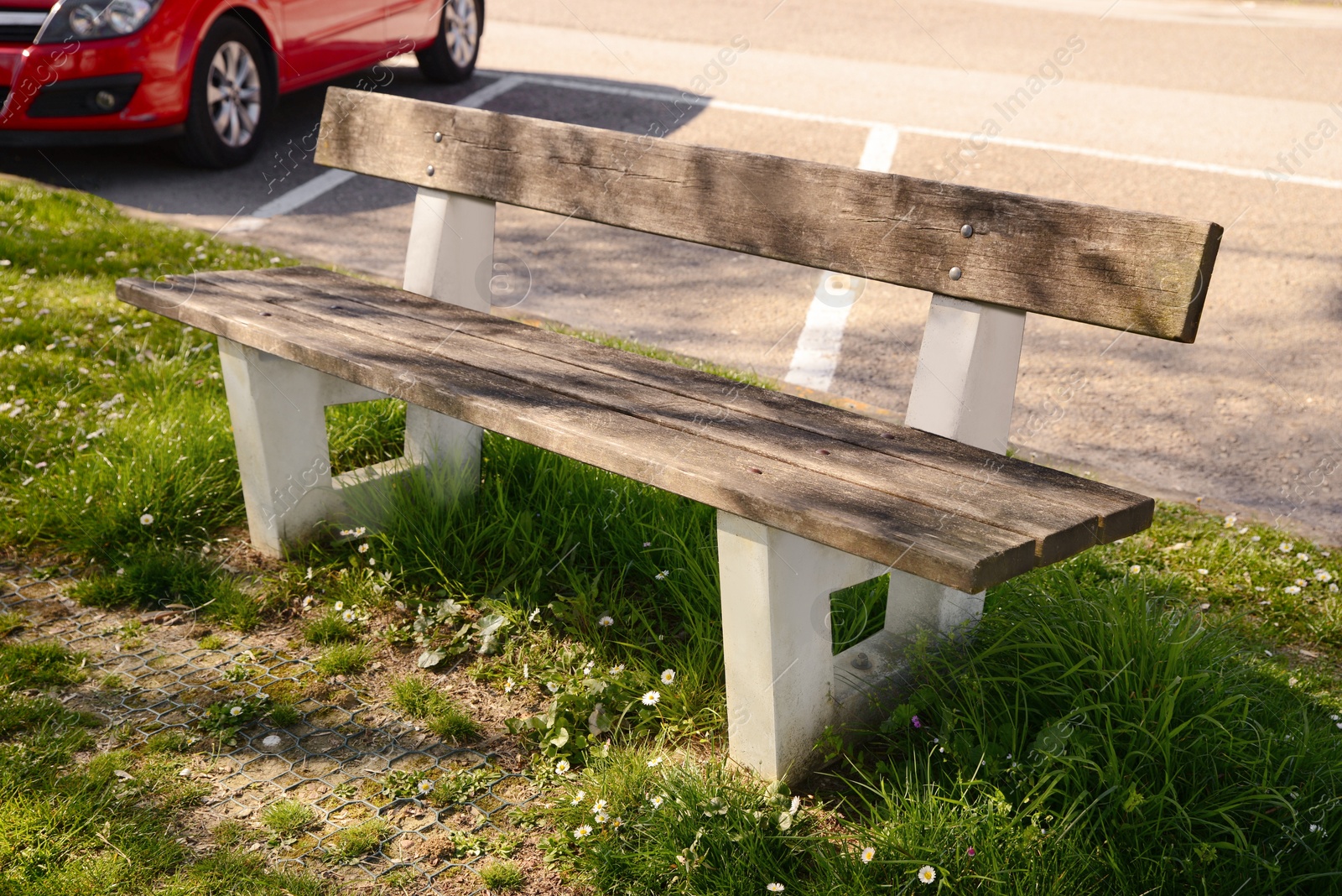 Photo of Wooden bench and green grass outdoors on sunny day