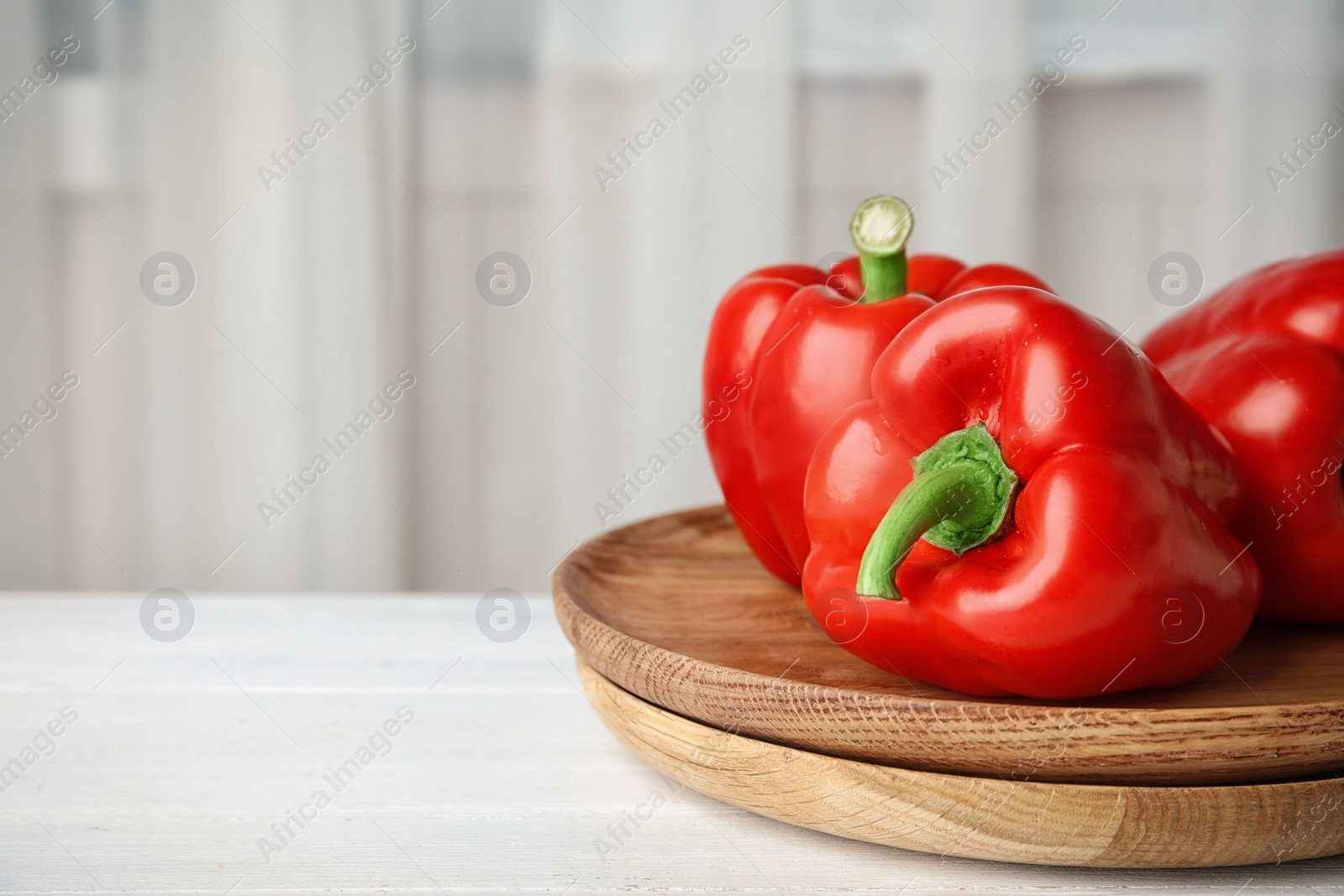 Photo of Plates with ripe paprika peppers on table