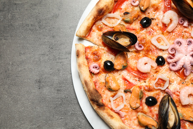 Delicious seafood pizza on grey table, top view