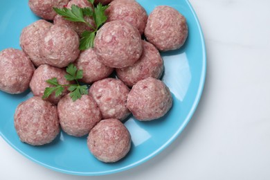 Many fresh raw meatballs on white table, top view