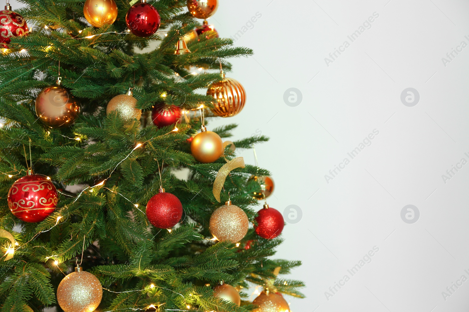 Photo of Beautiful Christmas tree with fairy lights and festive decor on white background